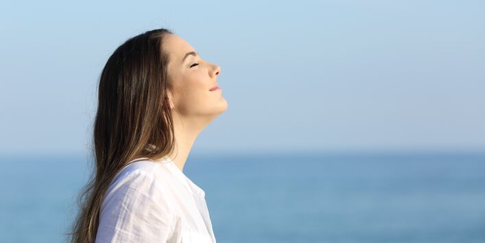 Frau atmet tief ein.