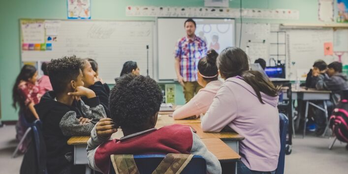 Schüler hören einem Lehrer zu.