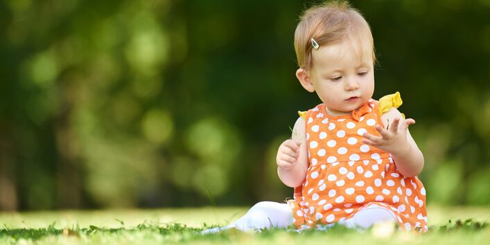 Ein Kleinkind auf einer Wiese.