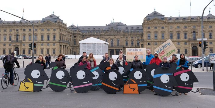 Teilnehmende stehen hinter den Maskottchen, die sie getragen haben.