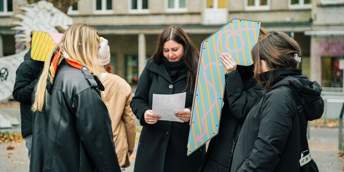 Teilnehmer*innen probieren das Tief-Seh-Rohr aus