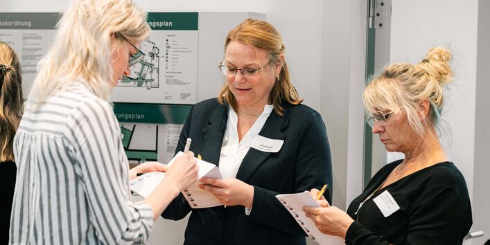 3 Teilnehmerinnen stehen beisammen und unterhalten sich angeregt