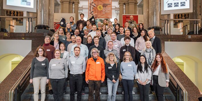 Auf einer Treppe sind die Teilnehmer*innen des EMW-Netzwerktreffens 2024 aufgestellt.