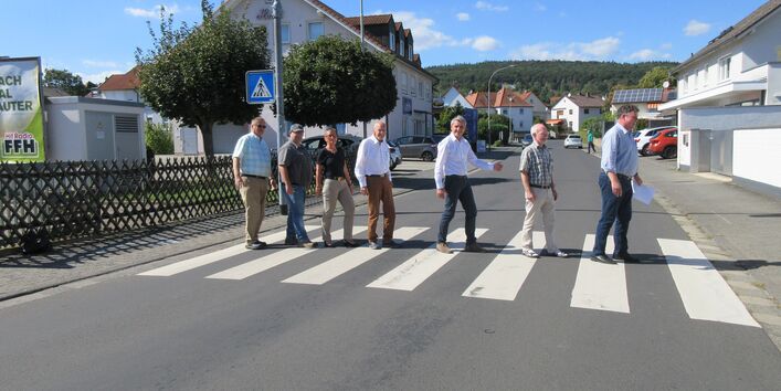Bürgerinnen und Bürger gehen über den Zebrastreifen, wie die Beatles auf dem Abbey-Road Cover
