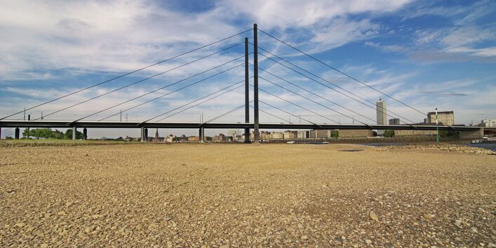 Eine Autobrücke führt über einen teils ausgetrockneten Fluß.