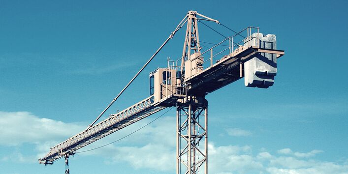 Building crane in front of a blue sky