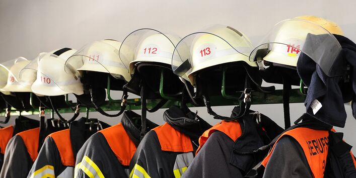 Aufgereihte Jacken und Helme der Berufsfeuerwehr