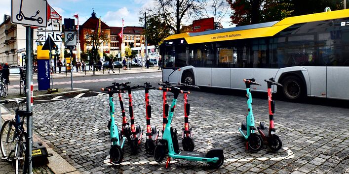 viele Leih-E-Tretroller in einer Reihe abgestellt in der Stadt