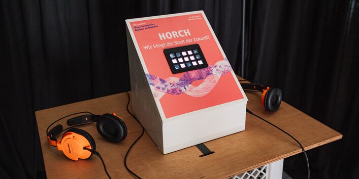 Über Knöpfe können Klänge zusammengestellt werden. Zwei Kopfhörer liegen bereit. 