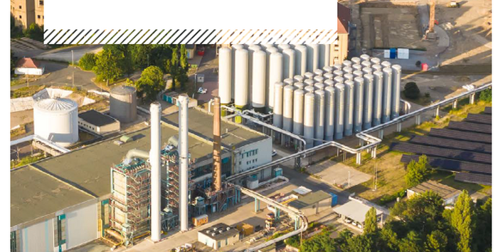 Titelseite der Broschüre "Mehr Nachhaltigkeit durch gekoppelte Infrastrukturen", das Hintergrundfoto zeigt ein Industriegebiet an einer Bahntrasse