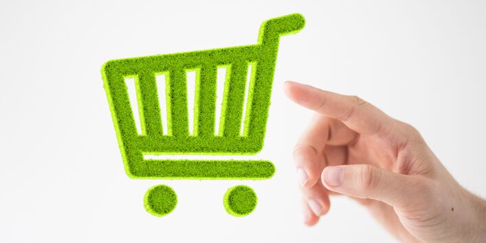 Hand tippt auf das Piktogramm eines grünen Einkaufswagens