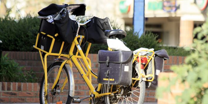 gelbes Postfahrad mit Packtaschen