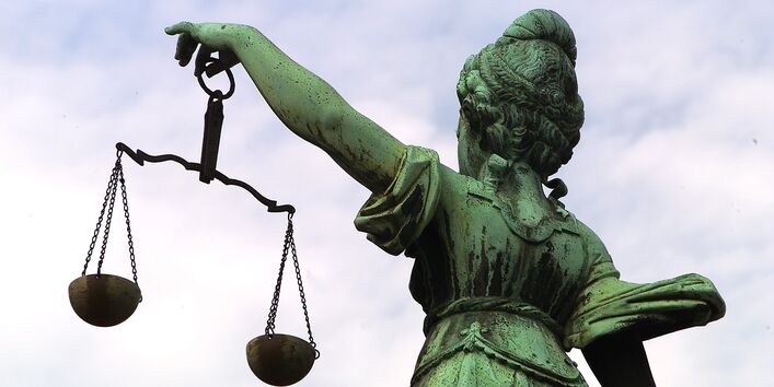 Bronze statue of Justitia, holding a pair of balances in her hand