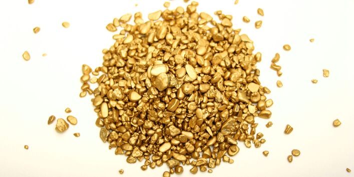 ein kleines Häufchen Goldklumpen auf einer weißen Unterlage