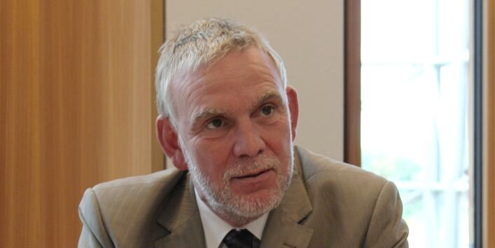 Der UBA-Präsident Jochen Flasbarth sitzt an einem Tisch - im Gespräch