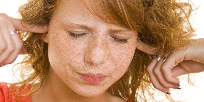 Auf dem Bild ist eine Frau zu sehen, die sich die Ohren zuhält.