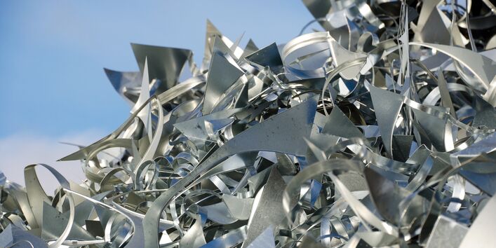 ein Man mit Bauhelm steht vor einer Landschaft mit Tagebau und einem Bagger