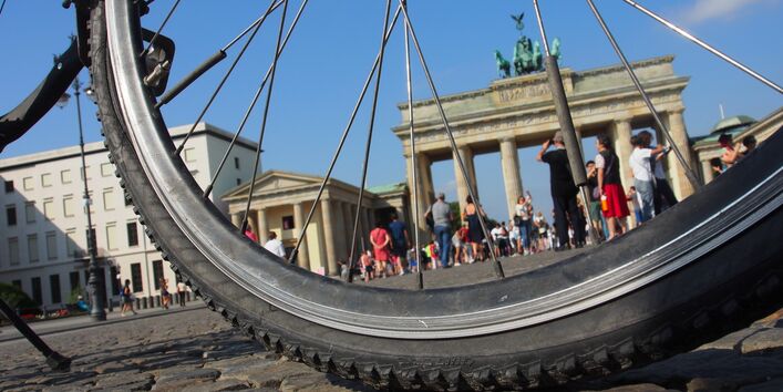 durch die Speichen eines Fahrradreifens ist das Brandenburger Tor in Berlin zu sehen