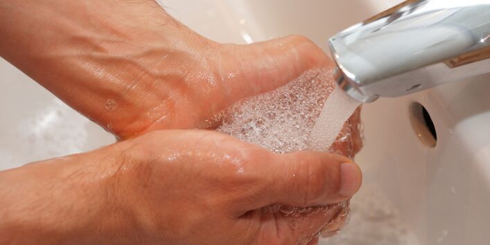zwei Hände unter dem Wasserhahn