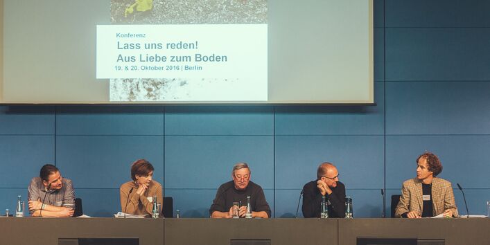 Aufnahme von fünf Teilnehmern der Podumsdiskussion, hinter ihnen eine Leinwand mit dem heutigen Thema