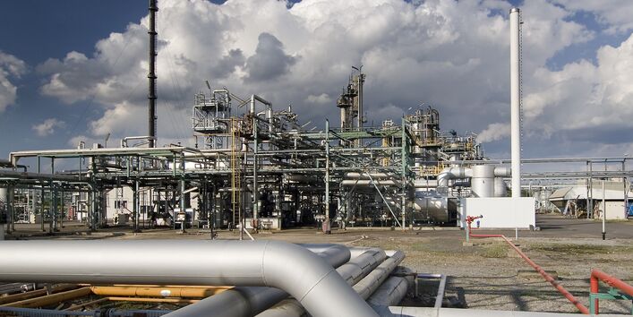 Nahaufnahme einer Chemieanlage vor wolkigem Himmel
