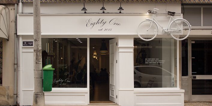 Schaufenster eines Friseursalons mit einem hängenden Fahrrad