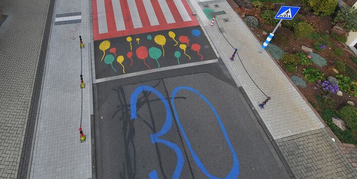 Blick auf die bunt gestaltete Kreuzung mit markierten Zebrastreifen und 30-er-Zone
