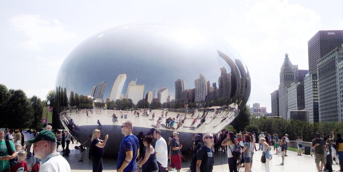 Skulptur eines riesigen metallenen "Wassertropfens" auf einem Platz in Chicago, drum herum viele Menschen, die diese besichtigen und fotografieren.