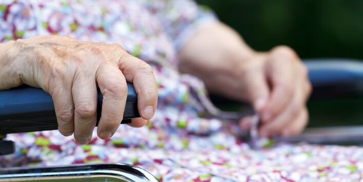 alte Frau sitzt im Rollstuhl