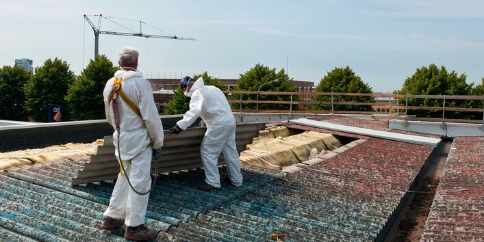 Workers remove asbestos roof sheets