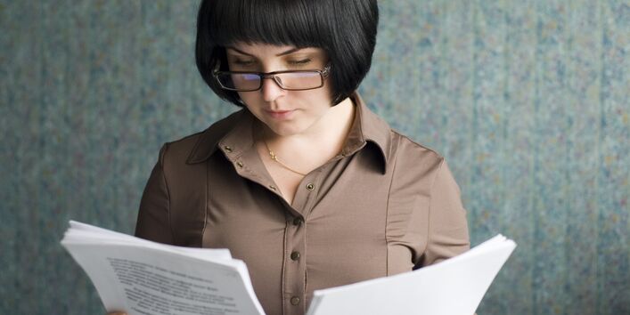 Frau schaut auf beschriebenes Papier