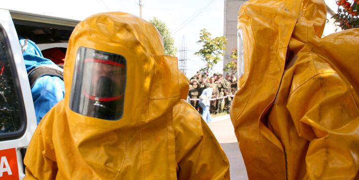 Männer in gelben Plastikanzügen beim Chemikalienunfall