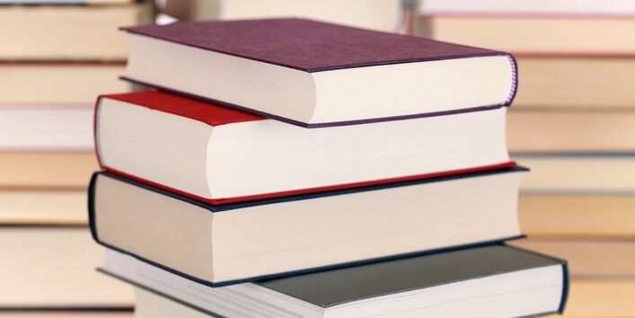 Stapel mit Büchern, die farbige Einbände tragen. 