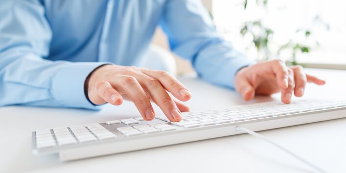 Ein Mann tippt auf die Tastatur.