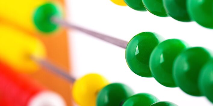 Rechenschieber mit grünen Kugeln im Vordergrund.