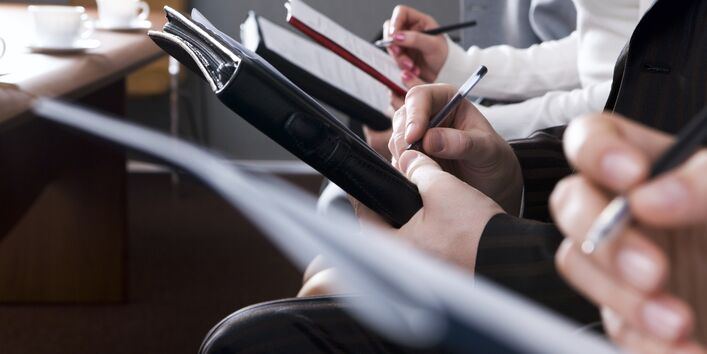 Nahaufnahme von Händen, die Notizen anfertigen