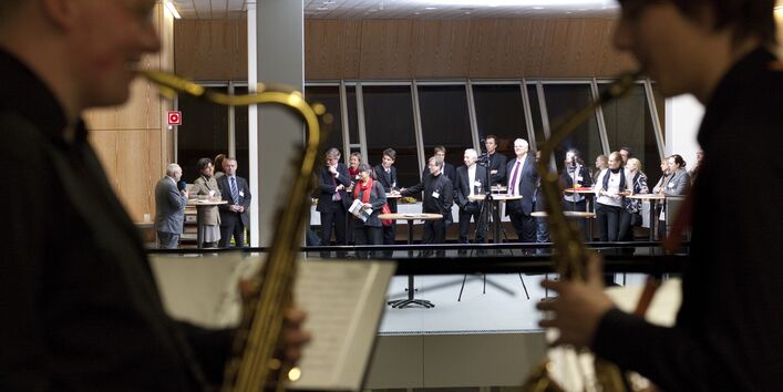 Zwei Saxophon-Spieler im Vordergrund, im Hintergrund der Empfang der Preisträger