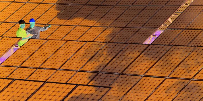 Two engineers discussing in an extensive photovoltaic installation
