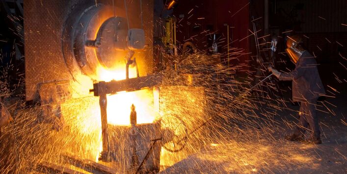 Eine Gießerei, bei der glühendes Metall verarbeitet wird und viele Funken sprühen.