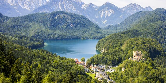 A lake with mountains around it and blue sky.