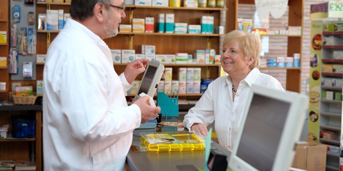 Foto von Beratungssituation am Tresen in einer Apotheke. 