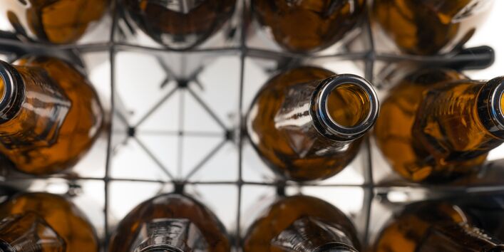 Eine Kiste mit leeren Bierflaschen von oben.