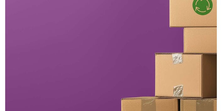 braune Pakete gestapelt vor einem lila Hintergrund