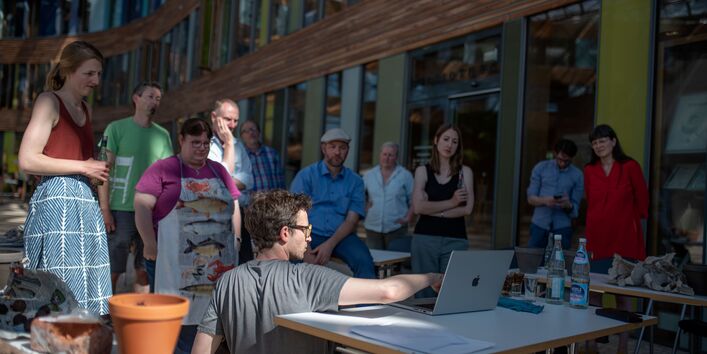 Eine Menschengruppe im UBA-Dessau schaut auf einen Laptop.