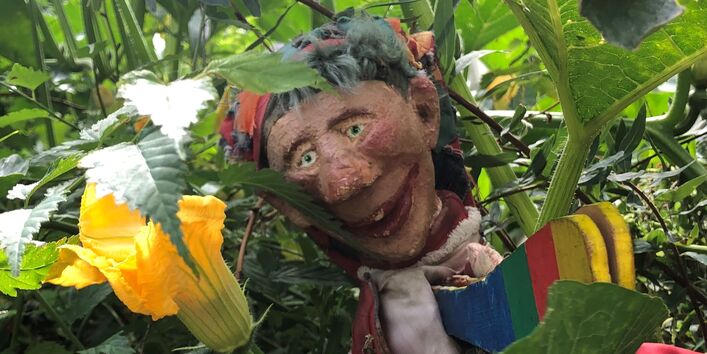 Kaspar-Puppe in Blumen