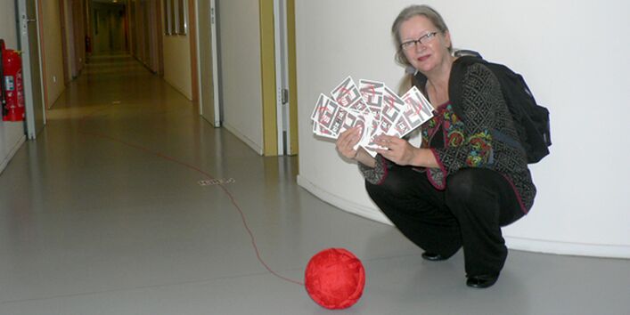 Christiane Keppler hockend mit Garnrolle & Schriftschablonen