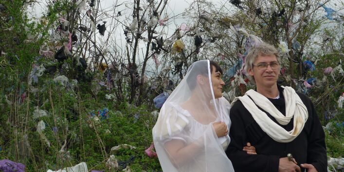 Ein Pärchen in festlicher Kleidung im Grünen