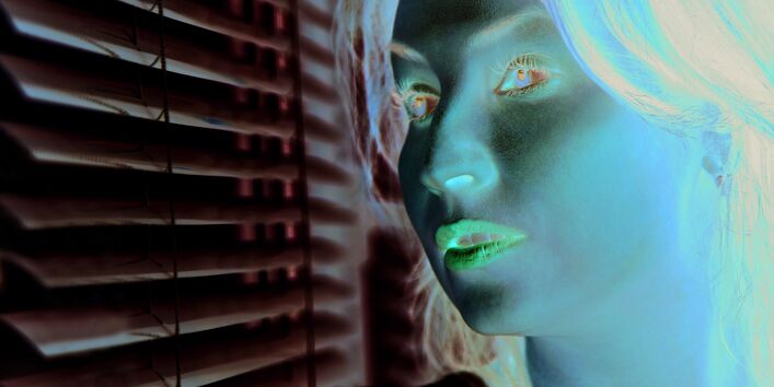 Das Bild zeigt Kopf und Schultern einer Frau, die mit skeptischem Blick aus dem Fenster schaut. Das Fenster ist durch eine Innenjalousie teil-verschattet.