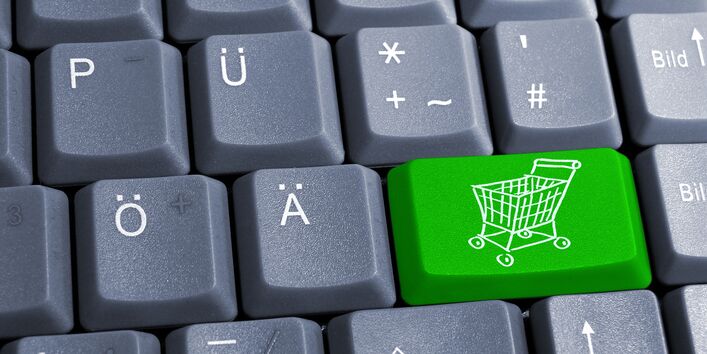 Computertastatur mit einer grünen Taste mit Einkaufswagen drauf