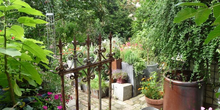 Schmiedeeiserne Tür öffnet sich zum Garten im Berliner Innenhof